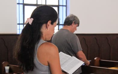 Mulher lendo a biblia dentro da igreja